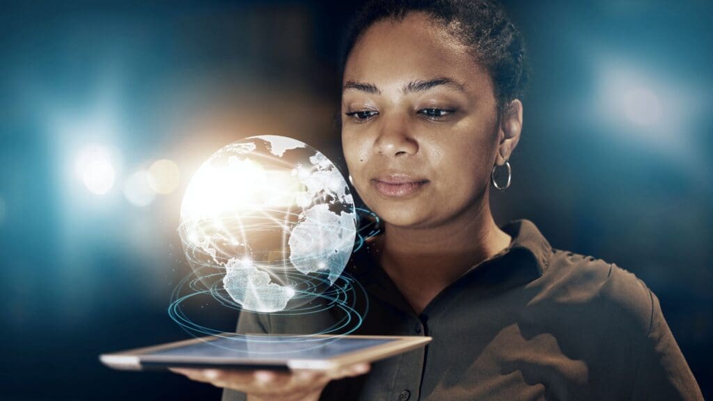 woman holding an ipad and the globe shining out of the screen