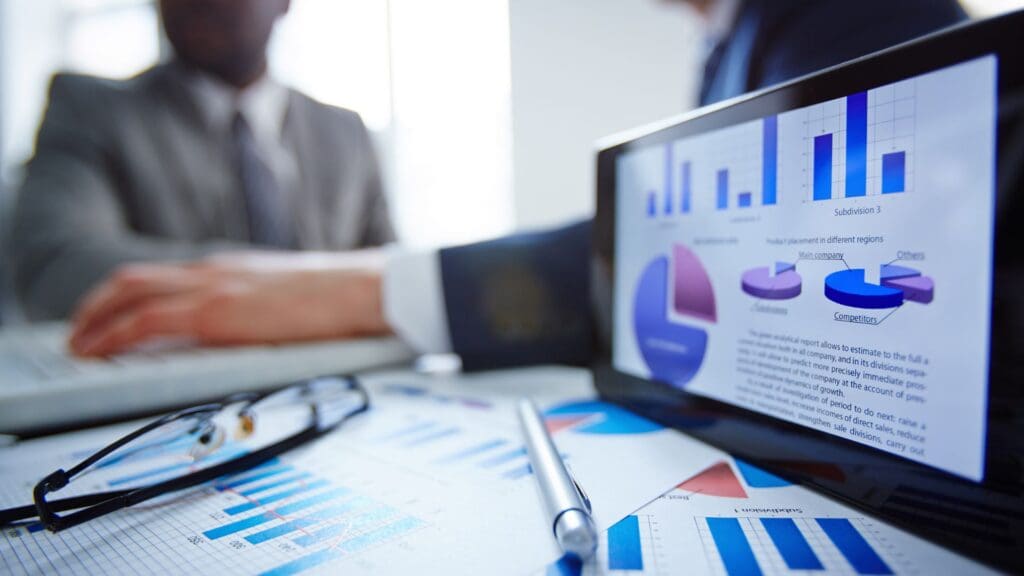 Ipad with graphs and charts, on a table with different print outs of similar graphs and charts