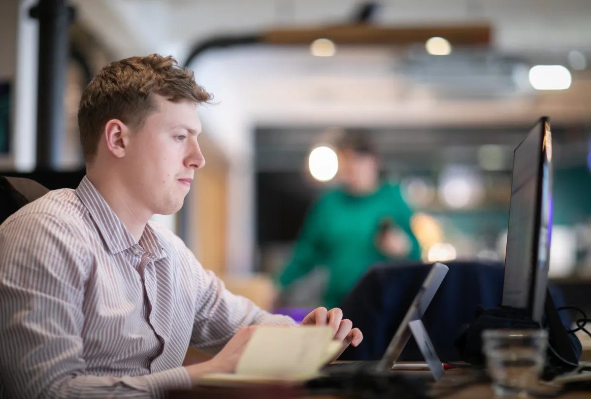 man sitting at desk working on his computer researching project bankability